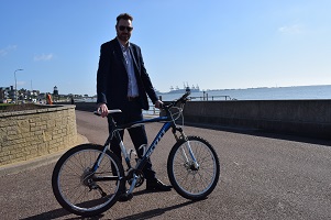 Councillor Alex Porter with a bike on Dovercourt promenade