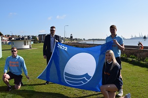 Tendring District Council Beach Patrol members with Councillor Alex Porter holding a Blue Flag at Dovercourt Bay